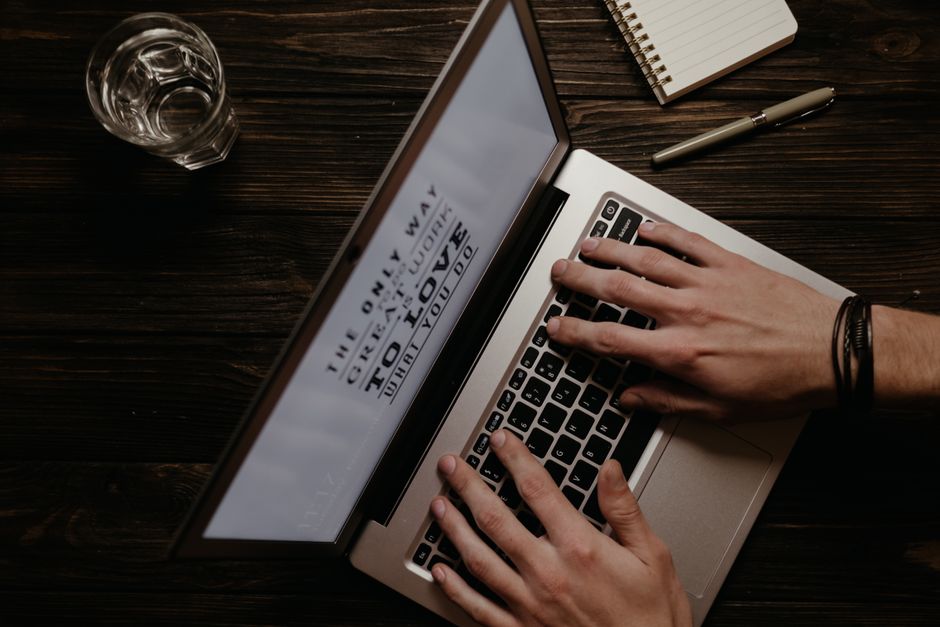 Personne rédigeant un article sur un ordinateur portable